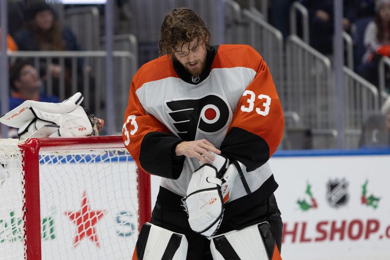 Nov 25, 2023; Elmont, New York, USA; Philadelphia Flyers goaltender Samuel Ersson (33) adjusts his pads during a break in action against the New York Islanders in overtime at UBS Arena. Mandatory Credit: Thomas Salus-USA TODAY Sports