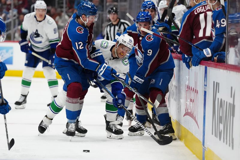 Feb 20, 2024; Denver, Colorado, USA; Colorado Avalanche center Ryan Johansen (12) and left wing Zach Parise (9) defend on Vancouver Canucks center Teddy Blueger (53) in the third period at Ball Arena. Mandatory Credit: Ron Chenoy-USA TODAY Sports