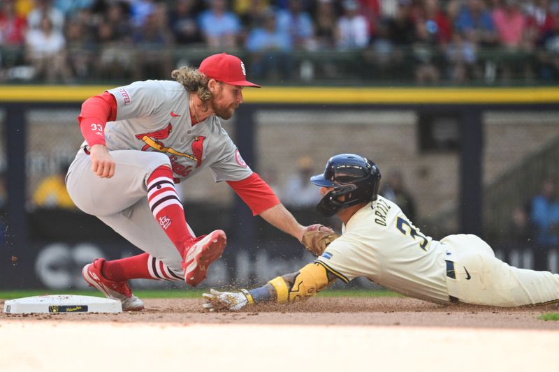 Sep 2, 2024; Milwaukee, Wisconsin, USA; St. Louis Cardinals second baseman Brendan Donovan (33) tags out Milwaukee Brewers third baseman Joseph Ortiz (3) trying to stretch a single into a double in the fourth inning at American Family Field. Mandatory Credit: Benny Sieu-USA TODAY Sports