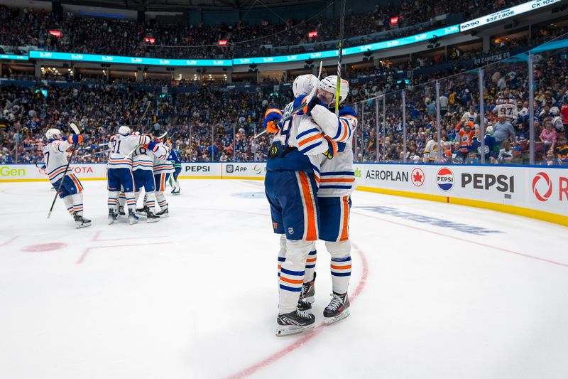 May 10, 2024; Vancouver, British Columbia, CAN; Edmonton Oilers forward Leon Draisaitl (29) and forward Connor McDavid (97) celebrate their victory against the Vancouver Canucks during the first overtime in game two of the second round of the 2024 Stanley Cup Playoffs at Rogers Arena. Mandatory Credit: Bob Frid-USA TODAY Sports