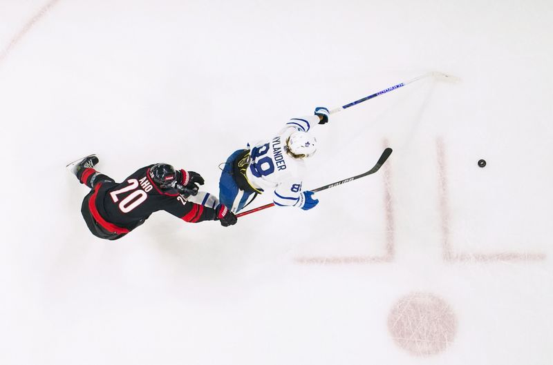 Mar 24, 2024; Raleigh, North Carolina, USA;  Toronto Maple Leafs right wing William Nylander (88) skates with the puck past Carolina Hurricanes center Sebastian Aho (20) during the second period at PNC Arena. Mandatory Credit: James Guillory-USA TODAY Sports