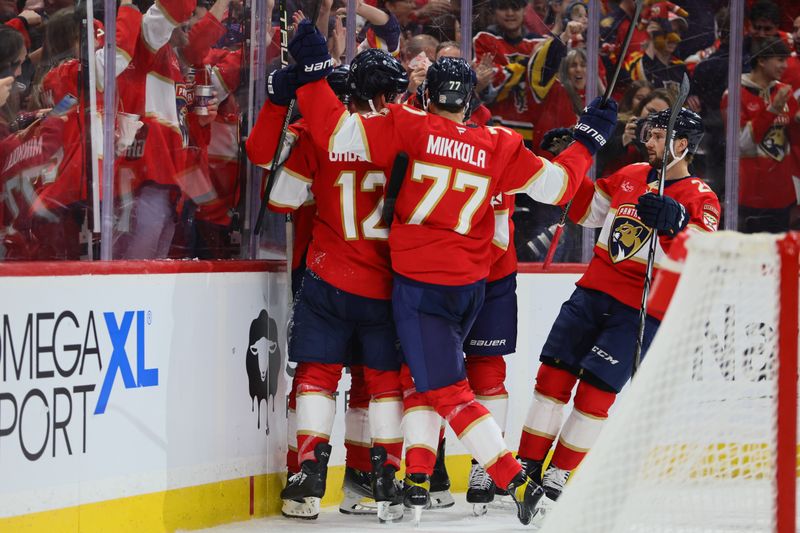 Oct 8, 2024; Sunrise, Florida, USA; Florida Panthers left wing Jonah Gadjovich (12) celebrates with teammates after scoring against the Boston Bruins during the second period at Amerant Bank Arena. Mandatory Credit: Sam Navarro-Imagn Images