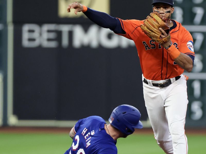 Jul 12, 2024; Houston, Texas, USA;  Houston Astros shortstop Jeremy Pena (3) forces out Texas Rangers catcher Jonah Heim (28) on a double play in the second inning at Minute Maid Park. Mandatory Credit: Thomas Shea-USA TODAY Sports