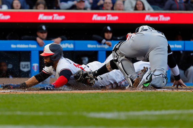 Apr 24, 2024; Minneapolis, Minnesota, USA; Minnesota Twins first baseman Carlos Santana (30) dives home and scores before Chicago White Sox catcher Korey Lee (26) can apply the tag on a single by catcher Christian Vazquez (not pictured) in the second inning at Target Field. Mandatory Credit: Bruce Kluckhohn-USA TODAY Sports