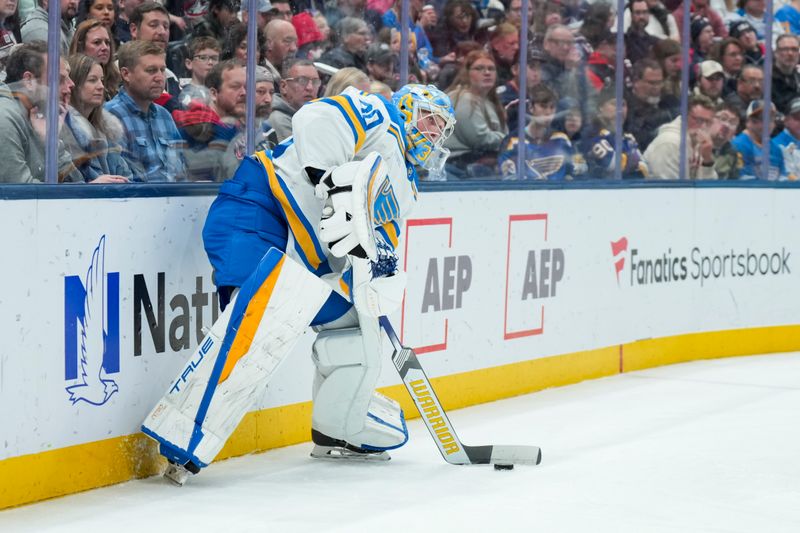 Nov 1, 2025; Columbus, Ohio, USA;  St. Louis Blues goaltender Joel Hofer (30) controls the puck against the Columbus Blue Jackets in the second period at Nationwide Arena. Mandatory Credit: Aaron Doster-Imagn Images
