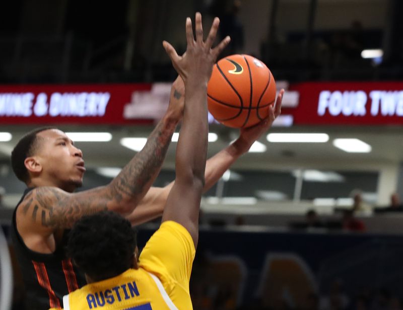 Feb 15, 2025; Pittsburgh, Pennsylvania, USA; Miami (Fl) Hurricanes guard Matthew Cleveland (left) shoots as Pittsburgh Panthers forward Zack Austin (55) defends during the second half at the Petersen Events Center. Mandatory Credit: Charles LeClaire-Imagn Images