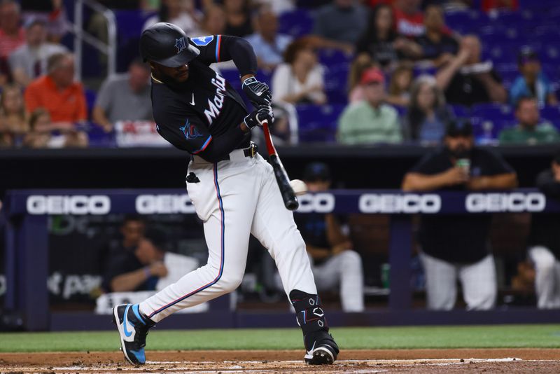 May 10, 2024; Miami, Florida, USA; Miami Marlins left fielder Bryan De La Cruz (14) hits a double against the Philadelphia Phillies during the first inning at loanDepot Park. Mandatory Credit: Sam Navarro-USA TODAY Sports