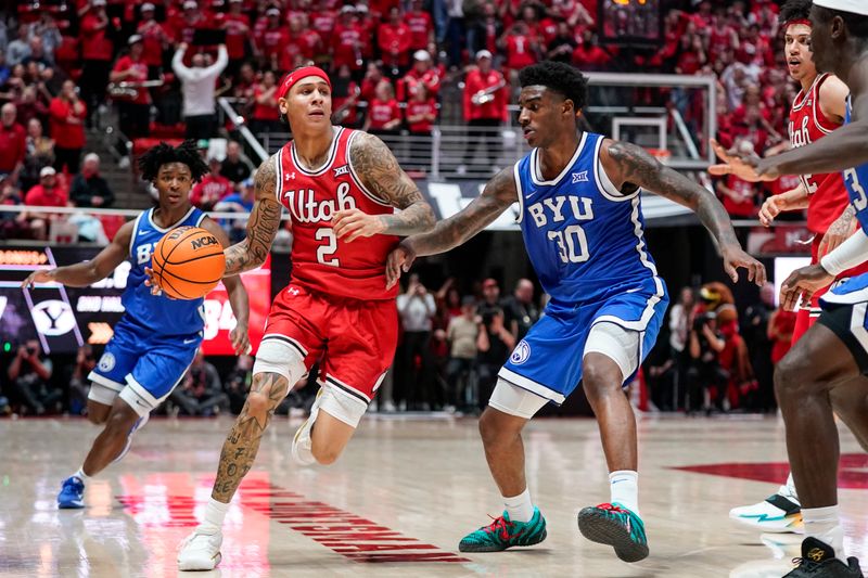 Jan 10, 2026; Salt Lake City, Utah, USA; Utah Utes guard Terrence Brown (2) drives while being defended by BYU Cougars forward Kennard Davis Jr. (30) during the second half at Jon M. Huntsman Center. Mandatory Credit: Aaron Baker-Imagn Images