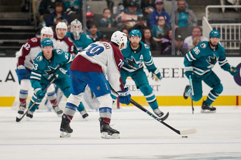 Oct 20, 2024; San Jose, California, USA; Colorado Avalanche defenseman Sam Malinski (70) controls the puck against San Jose Sharks right wing Barclay Goodrow (23), center Ty Dellandrea (53) and defenseman Jake Walman (96) during the second period at SAP Center at San Jose. Mandatory Credit: Robert Edwards-Imagn Images