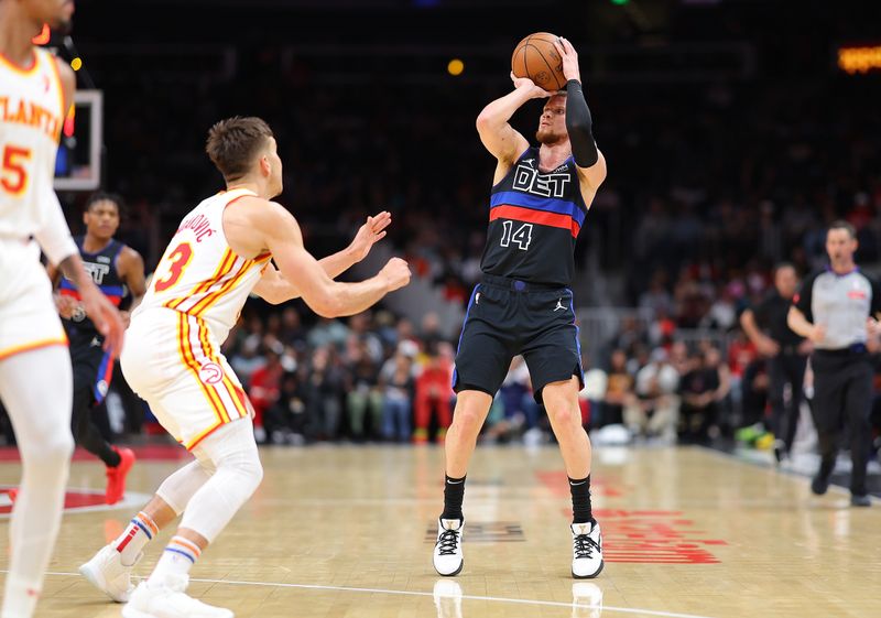 ATLANTA, GEORGIA - APRIL 03:  Malachi Flynn #18 of the Detroit Pistons attempts a three-point basket against Bogdan Bogdanovic #13 of the Atlanta Hawks during the fourth quarter at State Farm Arena on April 03, 2024 in Atlanta, Georgia.  NOTE TO USER: User expressly acknowledges and agrees that, by downloading and/or using this photograph, user is consenting to the terms and conditions of the Getty Images License Agreement.  (Photo by Kevin C. Cox/Getty Images)