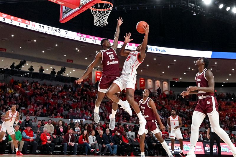 Nov 16, 2022; Houston, Texas, USA; Houston Cougars guard Marcus Sasser (0) shoots over Texas Southern Tigers guard Zytarious Mortle (12) during the first half at Fertitta Center. Mandatory Credit: Maria Lysaker-USA TODAY Sports