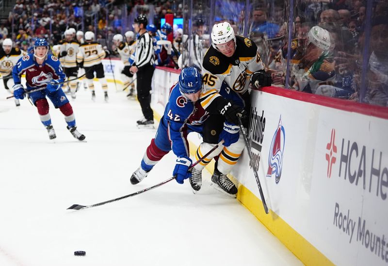 Oct 16, 2024; Denver, Colorado, USA; Colorado Avalanche defenseman Josh Manson (42) checks Boston Bruins left wing Cole Koepke (45) in the third period at Ball Arena. Mandatory Credit: Ron Chenoy-Imagn Images