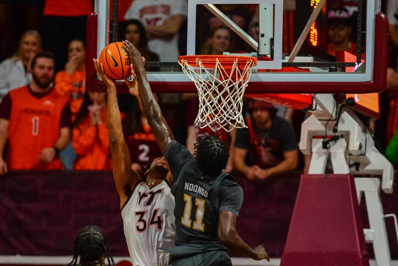 Jan 27, 2024; Blacksburg, Virginia, USA; Georgia Tech Yellow Jackets forward Baye Ndongo (11) blocks Virginia Tech Hokies forward Mylyjael Poteat (34) during the first half at Cassell Coliseum. Mandatory Credit: Brian Bishop-USA TODAY Sports