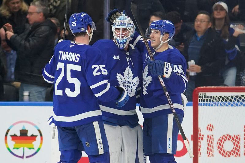 Nov 20, 2024; Toronto, Ontario, CAN; Toronto Maple Leafs defenseman Conor Timmins (25) and forward Alex Steeves congratulate goaltender Joseph Woll (60) on his shutout against the Vegas Golden Knights at Scotiabank Arena. Mandatory Credit: John E. Sokolowski-Imagn Images