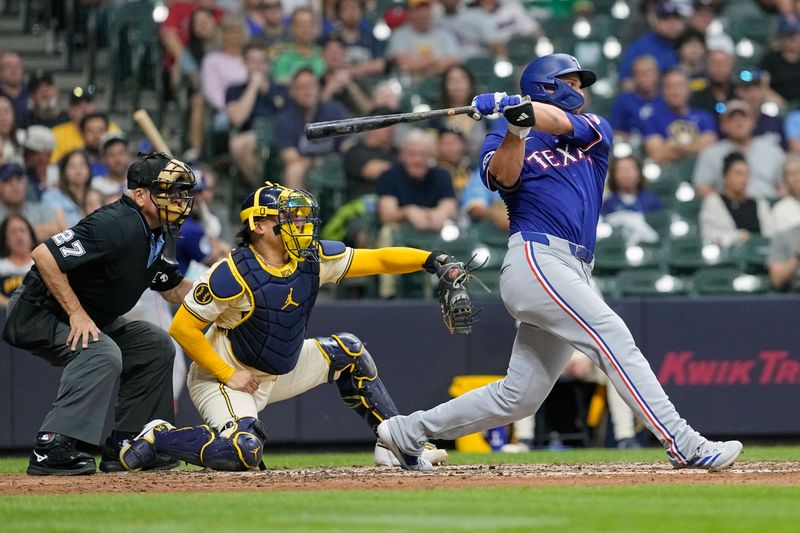 Jun 24, 2024; Milwaukee, Wisconsin, USA;  Texas Rangers shortstop Corey Seager (5) singles to drive in a run during the fifth inning against the Milwaukee Brewers at American Family Field. Mandatory Credit: Jeff Hanisch-USA TODAY Sports