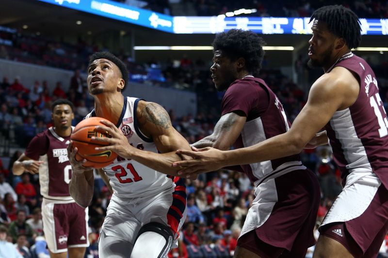 Feb 18, 2023; Oxford, Mississippi, USA; Mississippi Rebels forward Robert Allen (21) handles the ball as Mississippi State Bulldogs guard/forward Cameron Matthews (4) and forward Will McNair Jr. (13) defends during the second half at The Sandy and John Black Pavilion at Ole Miss. Mandatory Credit: Petre Thomas-USA TODAY Sports