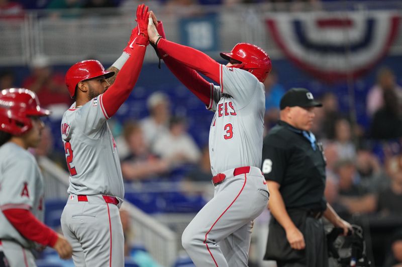 Apr 3, 2024; Miami, Florida, USA; Los Angeles Angels left fielder Taylor Ward (3) celebrates scoring a run with right fielder Aaron Hicks (12) in the third inning against the Miami Marlins at loanDepot Park. Mandatory Credit: Jim Rassol-USA TODAY Sports