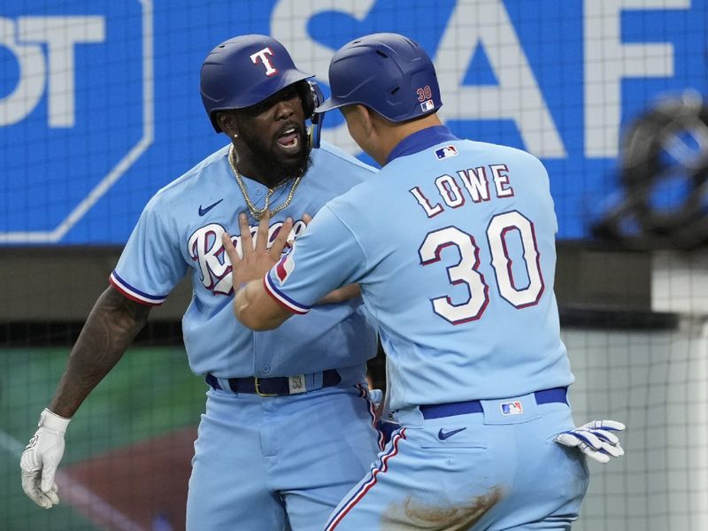 Jul 16, 2023; Arlington, Texas, USA; Texas Rangers right fielder Adolis Garcia (left) and first baseman Nathaniel Lowe (30) celebrate scoring on a single hit by third baseman Josh Jung (not shown) against the Cleveland Guardians during the eighth inning at Globe Life Field. Mandatory Credit: Jim Cowsert-USA TODAY Sports