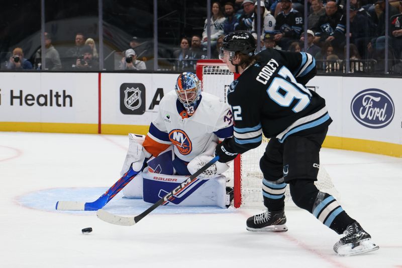 Nov 14, 2025; Salt Lake City, Utah, USA; Utah Mammoth center Logan Cooley (92) looks to pass as New York Islanders goaltender David Rittich (33) tends goal during the first period at Delta Center. Mandatory Credit: Rob Gray-Imagn Images
