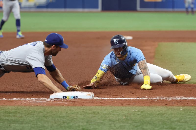 May 28, 2023; St. Petersburg, Florida, USA; Tampa Bay Rays center fielder Jose Siri (22) slides safe into third base as Los Angeles Dodgers infielder Chris Taylor (3)  attempted to tag him out during the fourth inning at Tropicana Field. Mandatory Credit: Kim Klement-USA TODAY Sports