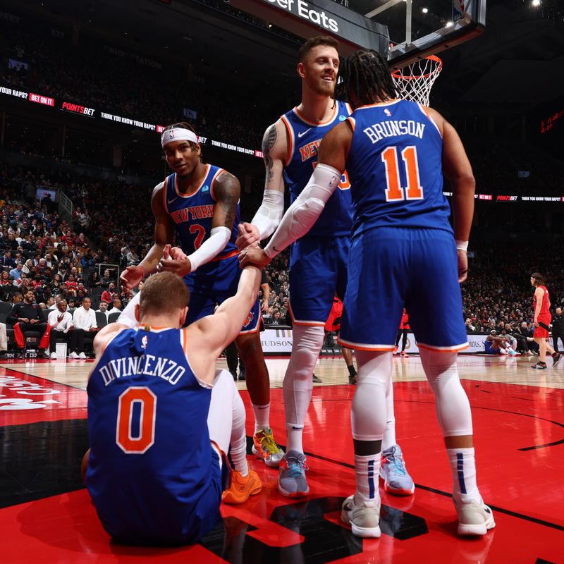 TORONTO, CANADA - MARCH 27: The New York Knicks help up Donte Divincenzo #0 during the game against the Toronto Raptors on March 27, 2024 at the Scotiabank Arena in Toronto, Ontario, Canada.  NOTE TO USER: User expressly acknowledges and agrees that, by downloading and or using this Photograph, user is consenting to the terms and conditions of the Getty Images License Agreement.  Mandatory Copyright Notice: Copyright 2024 NBAE (Photo by Vaughn Ridley/NBAE via Getty Images)