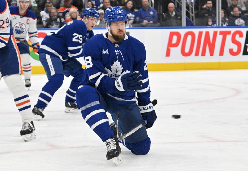 Nov 16, 2024; Toronto, Ontario, CAN;   Toronto Maple Leafs defenseman Jani Hakanpaa (28) kneels to block a shot against the Edmonton Oilers in the second period at Scotiabank Arena. Mandatory Credit: Dan Hamilton-Imagn Images