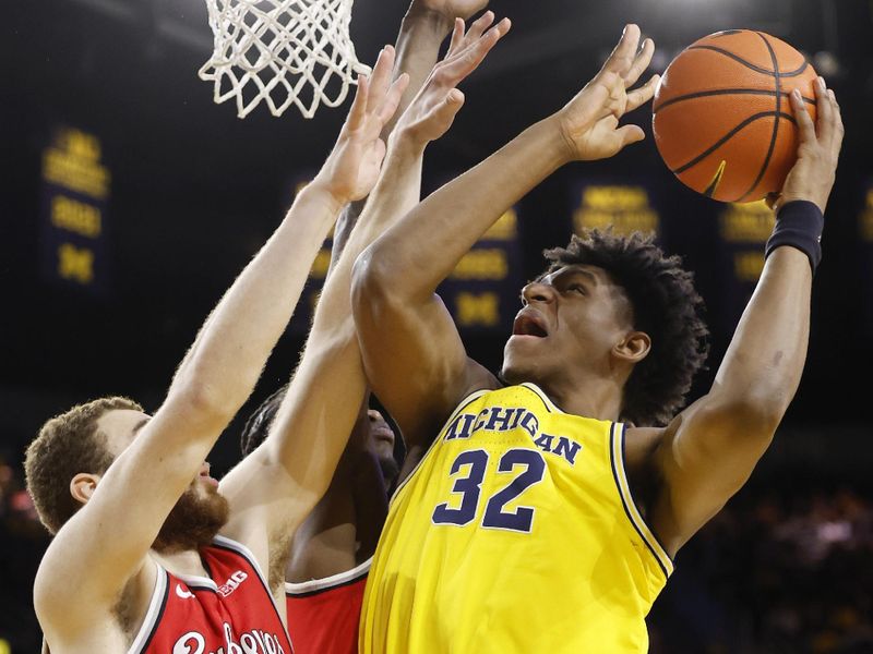 Jan 15, 2024; Ann Arbor, Michigan, USA; Michigan Wolverines forward Tarris Reed Jr. (32) shoots as Ohio State Buckeyes forward Jamison Battle (10) defends and center Felix Okpara (34) in the first half at Crisler Center. Mandatory Credit: Rick Osentoski-USA TODAY Sports