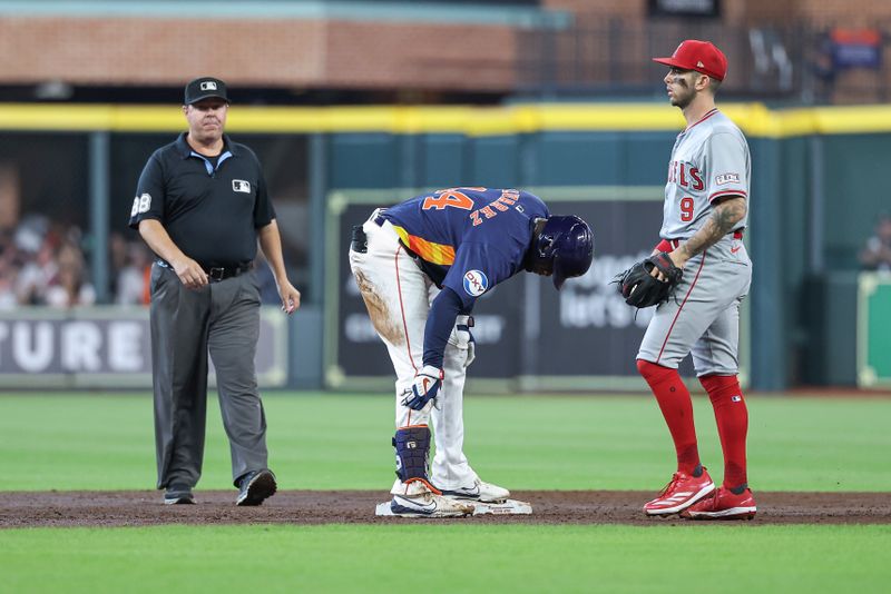 Sep 22, 2024; Houston, Texas, USA; Houston Astros left fielder Yordan Alvarez (44) holds his leg after hitting a double as Los Angeles Angels shortstop Zach Neto (9) looks on during the third inning at Minute Maid Park. Mandatory Credit: Troy Taormina-Imagn Images