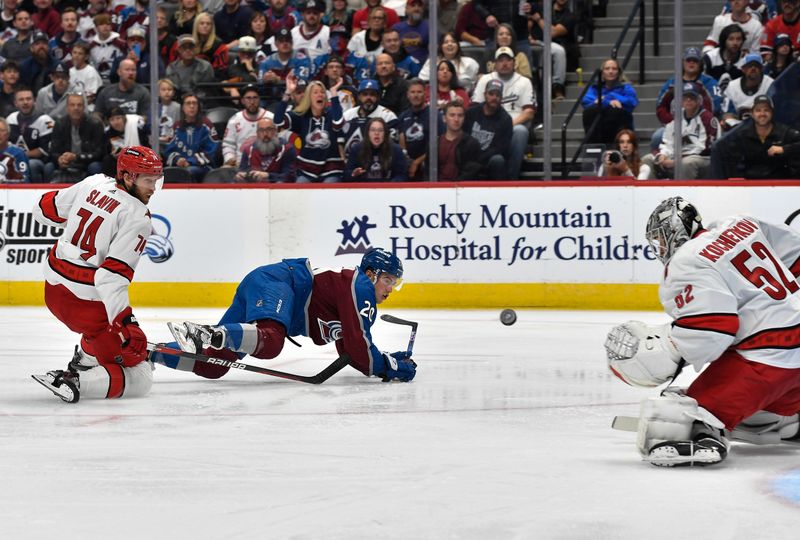 Oct 21, 2023; Denver, Colorado, USA; Carolina Hurricanes goaltender Pyotr Kochetkov (52) makes a save on a shot by Colorado Avalanche center Ross Colton (20) as Carolina Hurricanes defenseman Jaccob Slavin (74) looks on in the second period at Ball Arena. Mandatory Credit: John Leyba-USA TODAY Sports