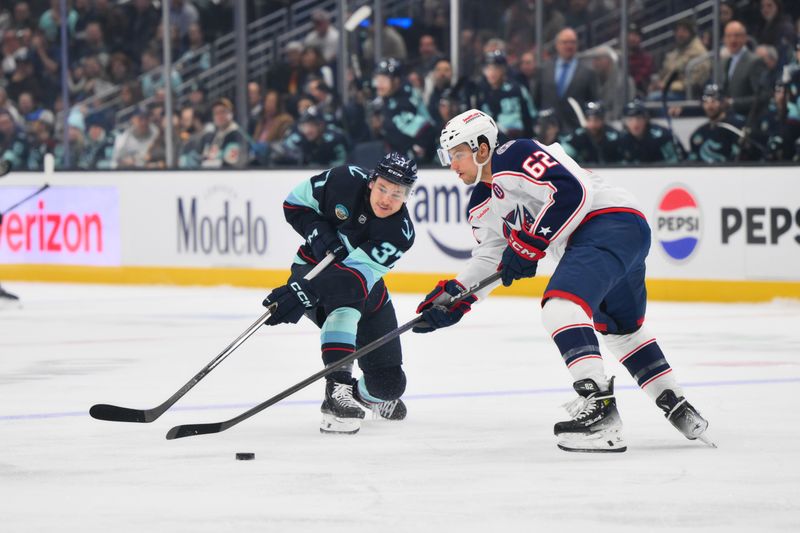 Nov 12, 2024; Seattle, Washington, USA; Seattle Kraken center Yanni Gourde (37) passes the puck past Columbus Blue Jackets right wing Kevin Labanc (62) during the first period at Climate Pledge Arena. Mandatory Credit: Steven Bisig-Imagn Images