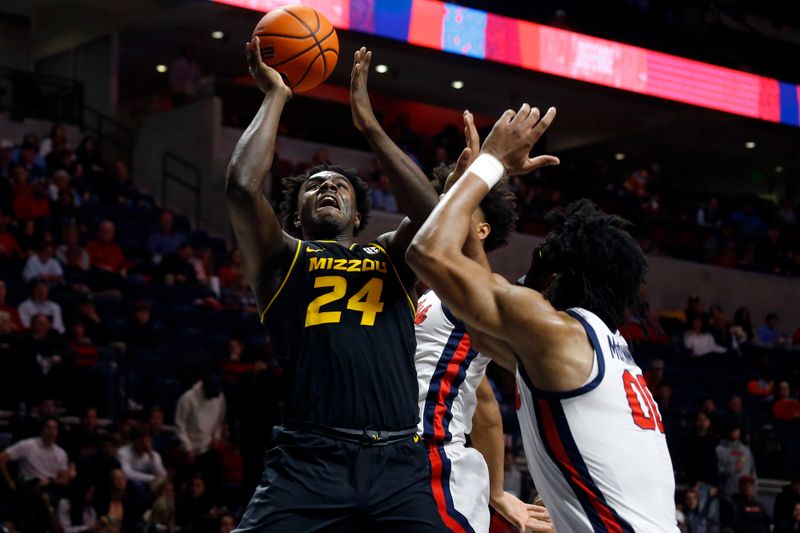 Jan 24, 2023; Oxford, Mississippi, USA; Missouri Tigers guard/forward Kobe Brown (24) shoots as Mississippi Rebels forward Jaemyn Brakefield (4) and Mississippi Rebels forward Jayveous McKinnis (0) defends during the first half at The Sandy and John Black Pavilion at Ole Miss. Mandatory Credit: Petre Thomas-USA TODAY Sports