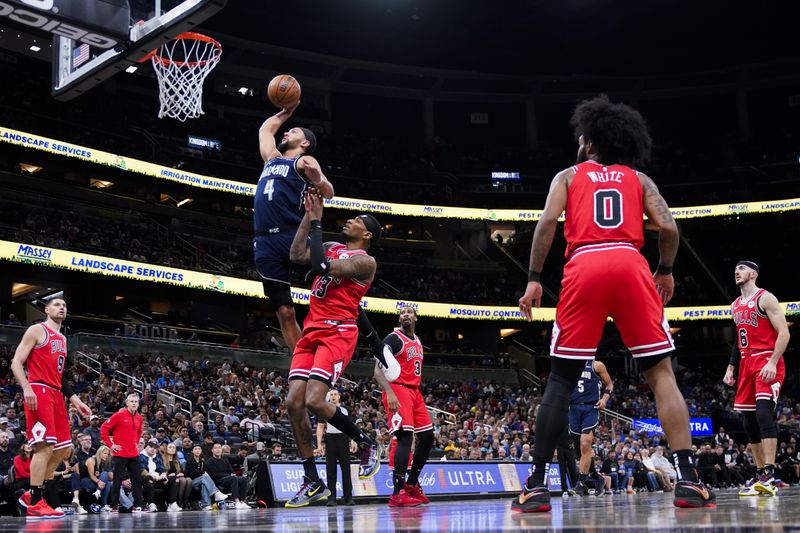 ORLANDO, FLORIDA - FEBRUARY 10: Jalen Suggs #4 of the Orlando Magic dunks the ball over Torrey Craig #13 of the Chicago Bulls during the first quarter at Kia Center on February 10, 2024 in Orlando, Florida. NOTE TO USER: User expressly acknowledges and agrees that, by downloading and or using this photograph, user is consenting to the terms and conditions of the Getty Images License Agreement. (Photo by Rich Storry/Getty Images)