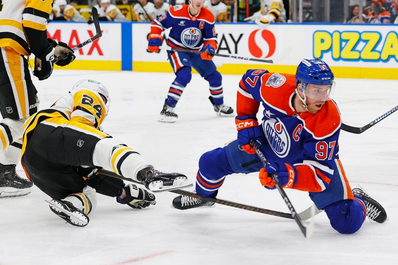 Oct 25, 2024; Edmonton, Alberta, CAN; Pittsburgh Penguins defensemen Kit Grzelcyk (24) trips up Edmonton Oilers forward Connor McDavid (97) during the third period at Rogers Place. Mandatory Credit: Perry Nelson-Imagn Images