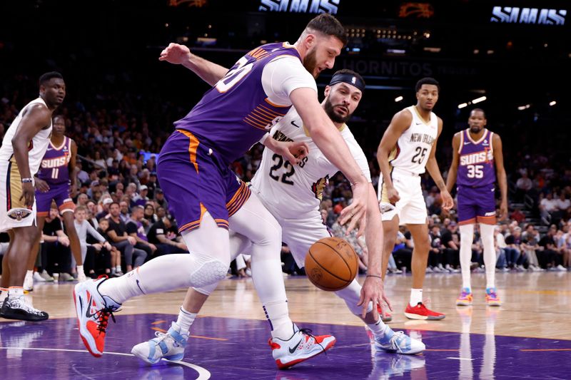 PHOENIX, ARIZONA - APRIL 07: Larry Nance Jr. #22 of the New Orleans Pelicans knocks the ball away from Jusuf Nurkic #20 of the Phoenix Suns during the first half at Footprint Center on April 07, 2024 in Phoenix, Arizona. NOTE TO USER: User expressly acknowledges and agrees that, by downloading and or using this photograph, User is consenting to the terms and conditions of the Getty Images License Agreement.  (Photo by Chris Coduto/Getty Images)