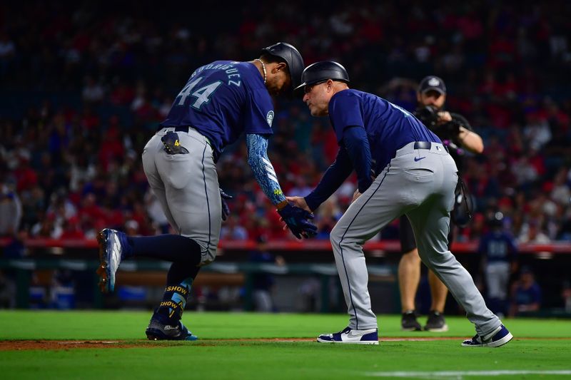 Aug 30, 2024; Anaheim, California, USA; Seattle Mariners center fielder Julio Rodríguez (44) is greeted by third base coach Manny Acta (14) after hitting a two run home run against the Los Angeles Angels at Angel Stadium. Mandatory Credit: Gary A. Vasquez-USA TODAY Sports