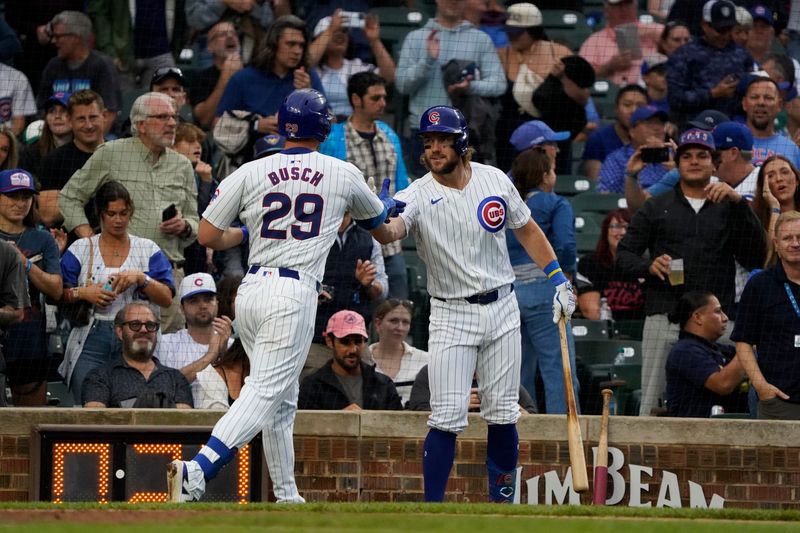 Sep 22, 2024; Chicago, Illinois, USA; Chicago Cubs first baseman Michael Busch (29) is greeted by left fielder Patrick Wisdom (16) after hitting a home run against the Washington Nationals during the fourth inning at Wrigley Field. Mandatory Credit: David Banks-Imagn Images