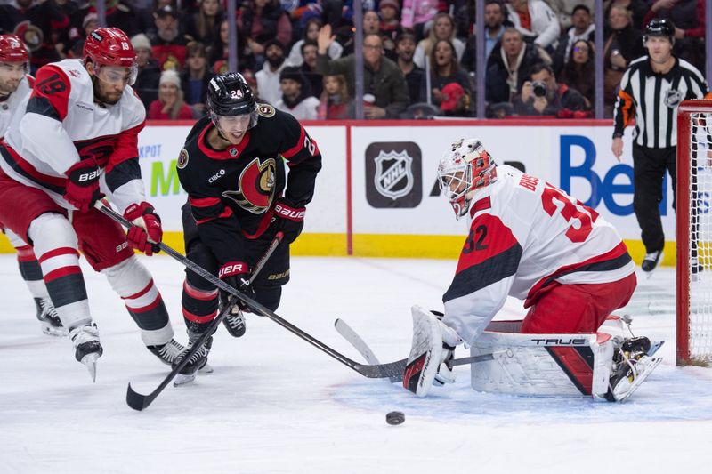 Jan 24, 2026; Ottawa, Ontario, CAN; Carolina Hurricanes defenseman K'Andre Miller (19) blocks Ottawa Senators center Dylan Cozens (24) as he skates in front of Hurricanes goalie Brandon Bussi (32) in the first period at the Canadian Tire Centre. Mandatory Credit: Marc DesRosiers-IMAGN Images