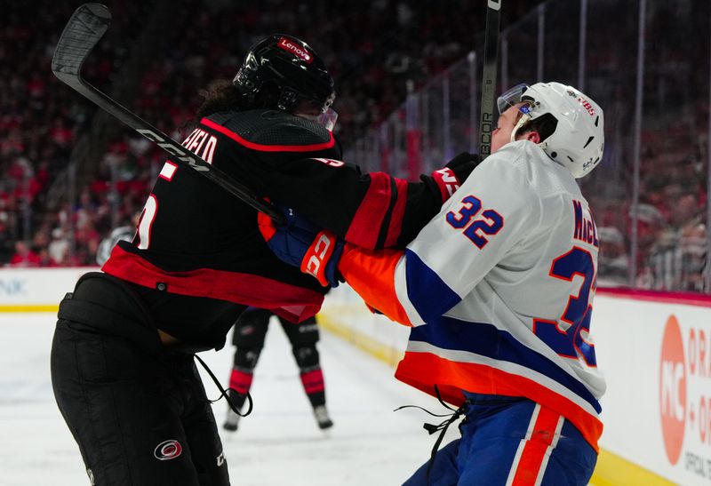 Apr 22, 2024; Raleigh, North Carolina, USA; Carolina Hurricanes defenseman Jalen Chatfield (5) checks New York Islanders center Kyle MacLean (32) during the second period in game two of the first round of the 2024 Stanley Cup Playoffs at PNC Arena. Mandatory Credit: James Guillory-USA TODAY Sports