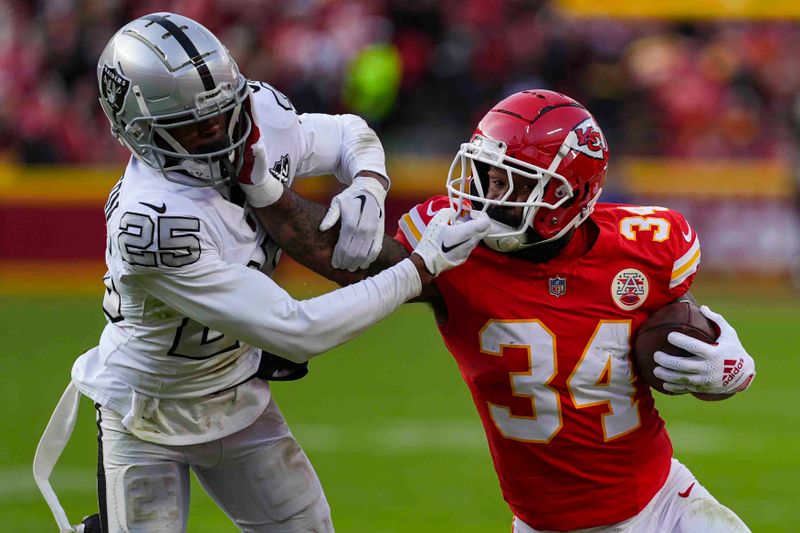 Kansas City Chiefs running back Samaje Perine (34) tries to hold off Las Vegas Raiders cornerback Decamerion Richardson (25) for a first down during the first half of an NFL football game in Kansas City, Mo., Friday, Nov. 29, 2024. (AP Photo/Charlie Riedel)