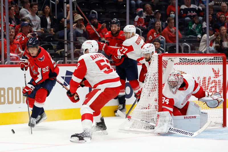 Sep 28, 2023; Washington, District of Columbia, USA; Washington Capitals center Evgeny Kuznetsov (92) skates with the puck behind Detroit Red Wings goaltender Alex Lyon (34) as Red Wings right wing Brogan Rafferty (52) defends in the first period at Capital One Arena. Mandatory Credit: Geoff Burke-USA TODAY Sports