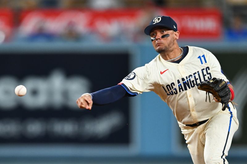 Jun 22, 2024; Los Angeles, California, USA; Los Angeles Dodgers shortstop Miguel Rojas (11) throws to first base against the Los Angeles Angels during the ninth inning at Dodger Stadium. Mandatory Credit: Jonathan Hui-USA TODAY Sports