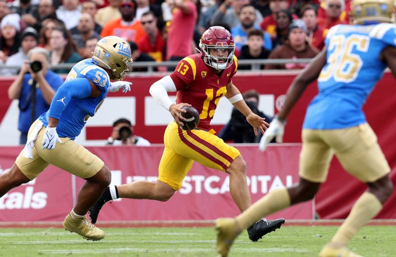 Nov 18, 2023; Los Angeles, California, USA; USC Trojans quarterback Caleb Williams (13) scrambles against UCLA Bruins linebacker Darius Muasau (53) during the first quarter at United Airlines Field at Los Angeles Memorial Coliseum. Mandatory Credit: Jason Parkhurst-USA TODAY Sports