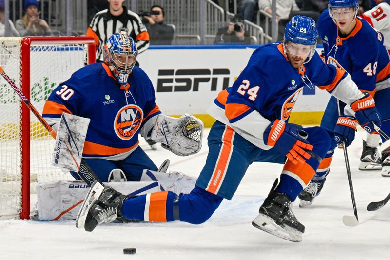 Jan 6, 2026; Elmont, New York, USA;  New York Islanders defenseman Scott Mayfield (24) attempts to block the puck in front of New York Islanders goaltender Ilya Sorokin (30) during the first period at UBS Arena. Mandatory Credit: Dennis Schneidler-Imagn Images