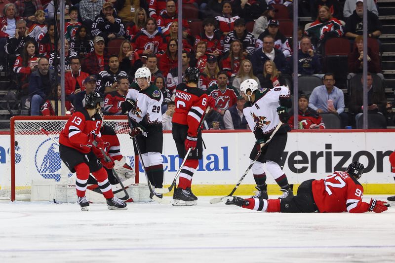 Oct 13, 2023; Newark, New Jersey, USA; Arizona Coyotes defenseman Sean Durzi (50) scores a goal on New Jersey Devils goaltender Akira Schmid (40) during the second period at Prudential Center. Mandatory Credit: Ed Mulholland-USA TODAY Sports