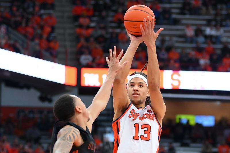 Jan 20, 2024; Syracuse, New York, USA; Syracuse Orange forward Benny Williams (13) shoots the ball as Miami (Fl) Hurricanes guard Matthew Cleveland (left) defends during the second half at the JMA Wireless Dome. Mandatory Credit: Rich Barnes-USA TODAY Sports