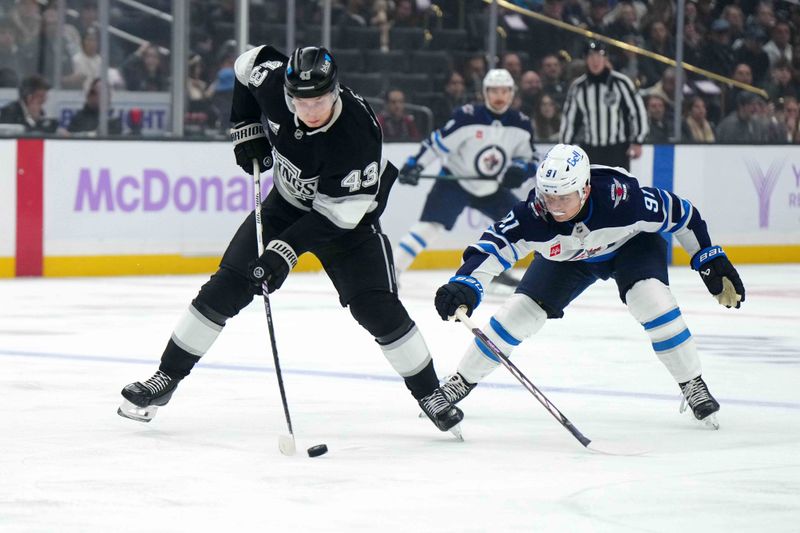 Nov 27, 2024; Los Angeles, California, USA; LA Kings defenseman Jacob Moverare (43) and Winnipeg Jets center Cole Perfetti (91) battle for the puck in the first period at Crypto.com Arena. Mandatory Credit: Kirby Lee-Imagn Images