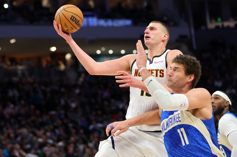 MILWAUKEE, WISCONSIN - FEBRUARY 12: Nikola Jokic #15 of the Denver Nuggets is defended by Brook Lopez #11 of the Milwaukee Bucks during the second half of a game at Fiserv Forum on February 12, 2024 in Milwaukee, Wisconsin. NOTE TO USER: User expressly acknowledges and agrees that, by downloading and or using this photograph, User is consenting to the terms and conditions of the Getty Images License Agreement. (Photo by Stacy Revere/Getty Images)