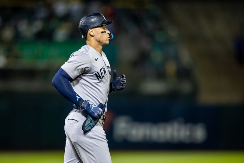 Sep 20, 2024; Oakland, California, USA; New York Yankees outfielder Aaron Judge (99) goes to first on a walk during the sixth inning against the Oakland Athletics at Oakland-Alameda County Coliseum. Mandatory Credit: Bob Kupbens-Imagn Images