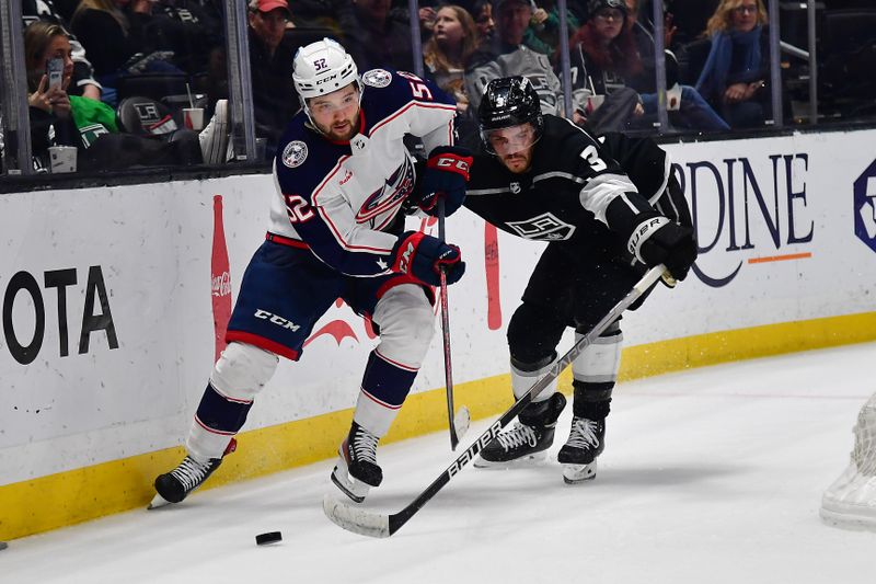 Mar 16, 2023; Los Angeles, California, USA; Los Angeles Kings defenseman Matt Roy (3) plays for the puck against Columbus Blue Jackets right wing Emil Bemstrom (52) during the third period at Crypto.com Arena. Mandatory Credit: Gary A. Vasquez-USA TODAY Sports