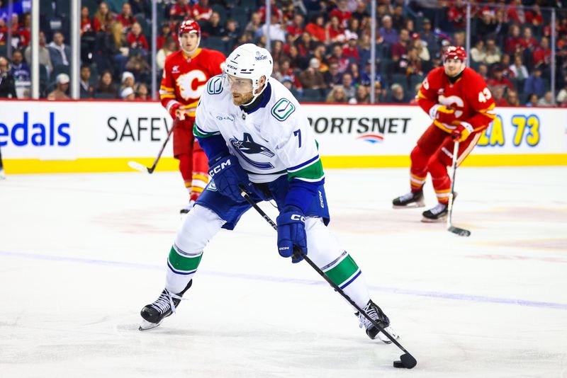 Sep 28, 2024; Calgary, Alberta, CAN; Vancouver Canucks defenseman Carson Soucy (7) controls the puck against the Calgary Flames during the third period at Scotiabank Saddledome. Mandatory Credit: Sergei Belski-Imagn Images